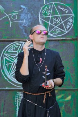 Rahip gibi giyinmiş bir adam. Cadılar Bayramı resmi. Sihir eksikliği.