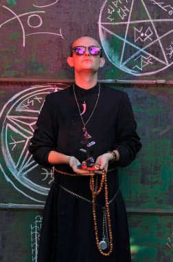 Rahip gibi giyinmiş bir adam. Cadılar Bayramı resmi. Sihir eksikliği.