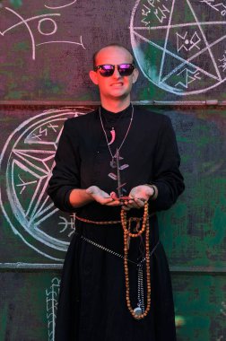 Rahip gibi giyinmiş bir adam. Cadılar Bayramı resmi. Sihir eksikliği.