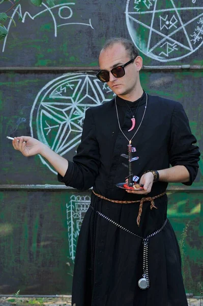 Rahip gibi giyinmiş bir adam. Cadılar Bayramı resmi. Sihir eksikliği.