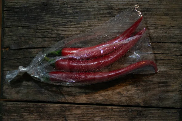 Rote Paprika Einer Plastikverpackung Auf Einem Hölzernen Hintergrund Drei Große — Stockfoto