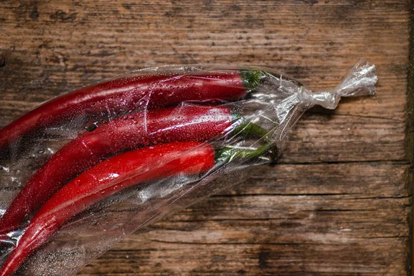 Red Hot Pepper Plastic Package Wooden Background Three Large Chili — Stock Photo, Image