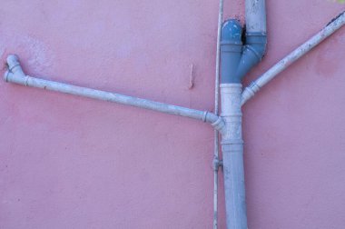 Duvarın dış tarafında plastik kanalizasyon borusu var.