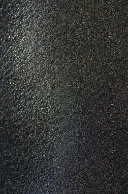 Deniz kıyısındaki siyah volkanik manyetik kum. Sahilin arka planında dalgalar birbirine yakın.. 