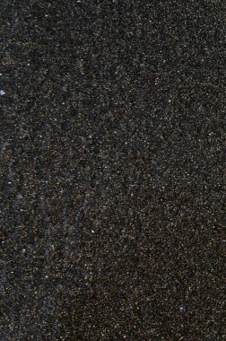 Deniz kıyısındaki siyah volkanik manyetik kum. Sahilin arka planında dalgalar birbirine yakın.. 