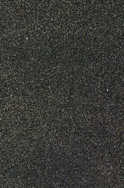 Deniz kıyısındaki siyah volkanik manyetik kum. Sahilin arka planında dalgalar birbirine yakın.. 