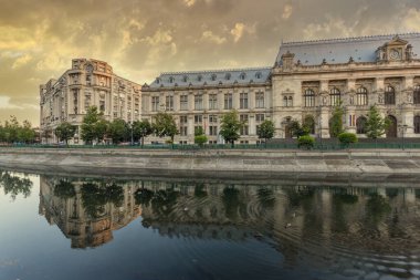 BUCHAREST, ROMANIA - 16 Ağustos 2021: Romanya 'nın Bükreş kentinin merkezinden geçen Adalet Sarayı ve Dambovita Nehri' nin gün batımı manzarası