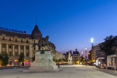 BUCHAREST, ROMANIA - 17 Ağustos 2021: Romanya 'nın Bükreş kentinin şehir merkezindeki Üniversite Meydanı' nın gün batımı manzarası