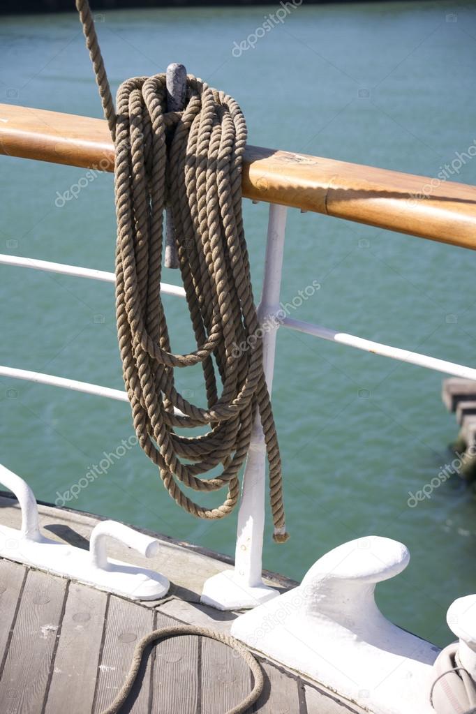 A blue and white nautical rope would around a chrome pulley on a