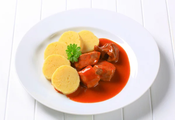 Pork in tomato sauce with potato dumplings — Stock Photo, Image