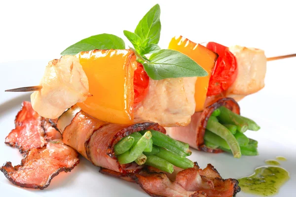 Chicken skewer and bacon-wrapped green beans — Stock Photo, Image