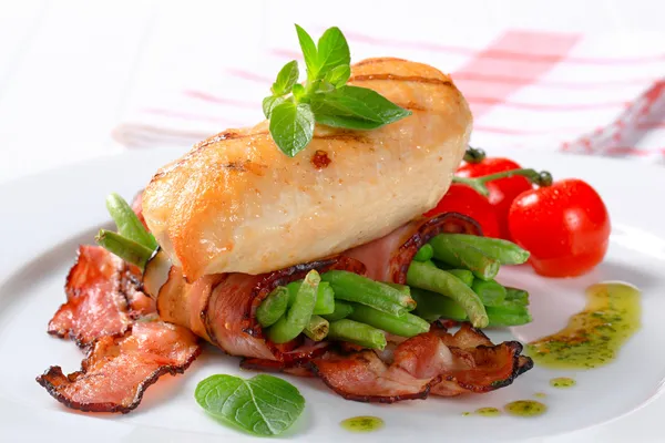 Grilled chicken breast with bacon-wrapped green beans — Stock Photo, Image