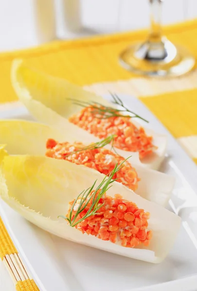 Ensalada de lentejas rojas sobre hojas frescas de endibia — Foto de Stock