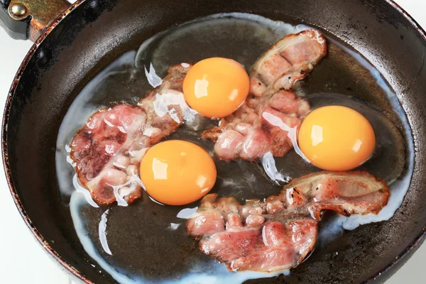 Voorbereiding van gebakken eieren met spek — Stockfoto