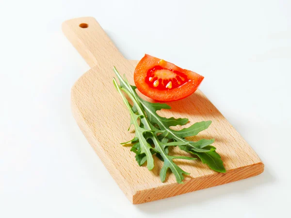Rocket leaves on cutting board — Stock Photo, Image