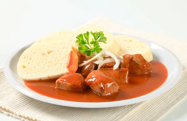 Varkensvlees in tomatensaus met knoedels — Stockfoto