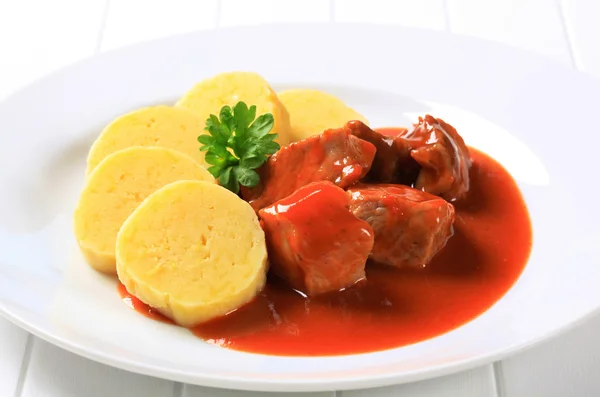 Schweinefleisch in Tomatensauce mit Kartoffelknödeln — Stockfoto
