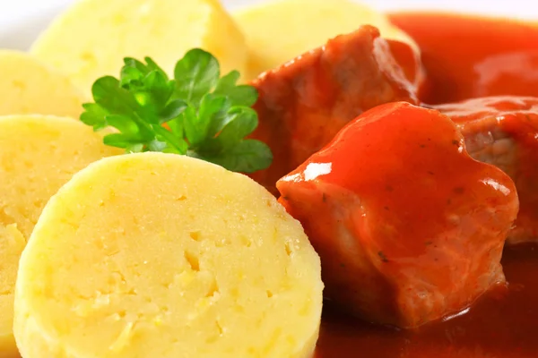 Varkensvlees in tomatensaus met aardappel knoedels — Stockfoto