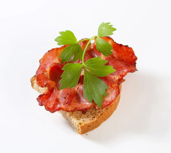 Pancetta fritta croccante su una fetta di pane — Foto Stock