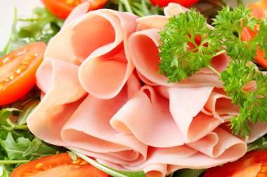 roka yaprakları ve domates ile dilimlenmiş jambon