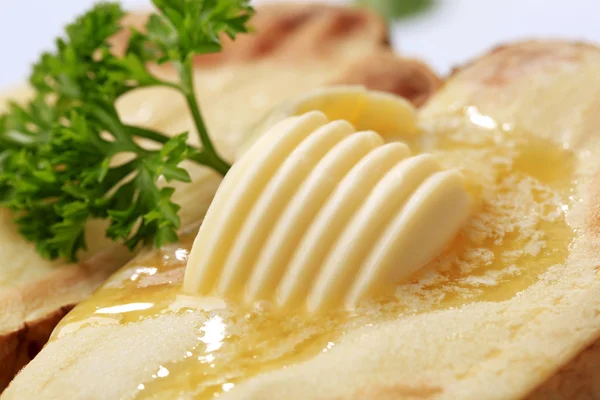 Butter auf Ofenkartoffeln schmelzen — Stockfoto