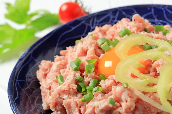 Carne fresca molida y yema de huevo en un tazón — Foto de Stock