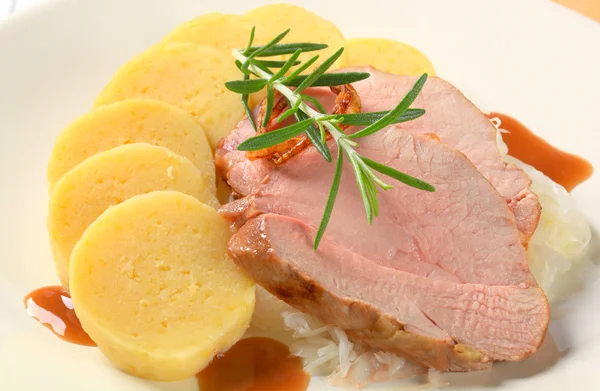 Varkensvlees met aardappel knoedels en witte kool — Stockfoto