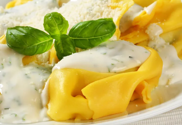 Ricotta-Spinat-Tortelloni mit Sahnesoße und Parmesan — Stockfoto