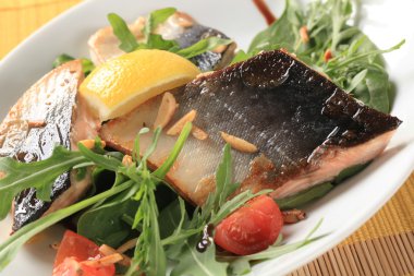 Balık fileto yeşil salata ve kıyılmış badem