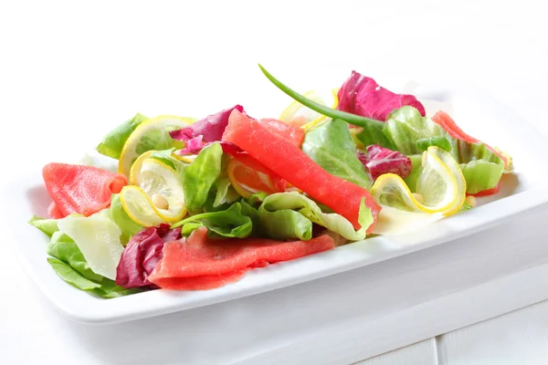 Lechuga con rodajas finas de limón y carne cruda — Foto de Stock