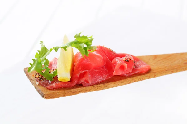 Slices of raw beef on spatula — Stock Photo, Image