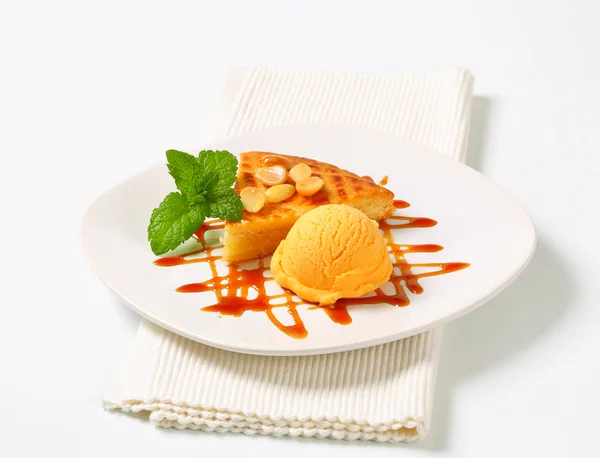 Almond cake with ice cream and caramel sauce — Stock Photo, Image
