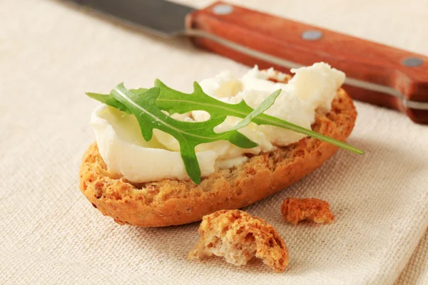 Crisp roll with cheese spread — Stock Photo, Image