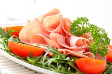 roka yaprakları ve domates ile dilimlenmiş jambon
