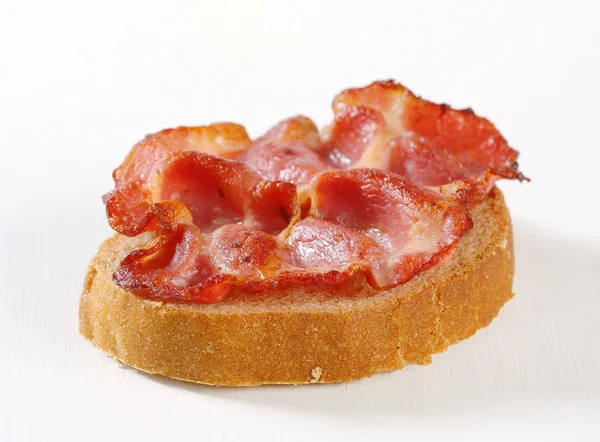 Krokante segment van varkensvlees op brood — Stockfoto
