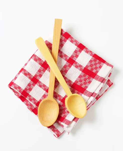 Checked tea towel and wooden spoons — Stock Photo, Image