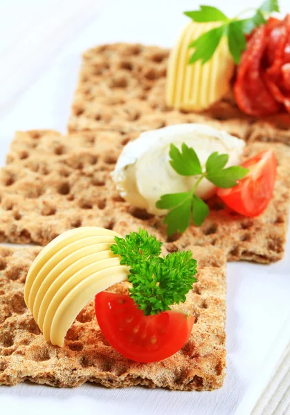 Whole grain crispbread with various toppings — Stock Photo, Image