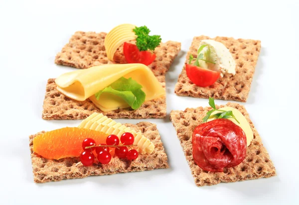 Whole grain crispbread with various toppings — Stock Photo, Image