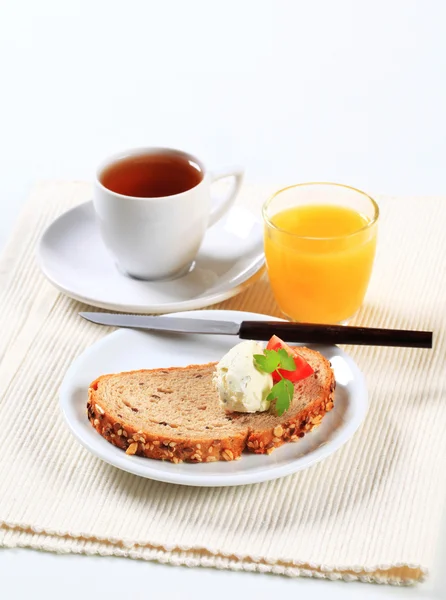 Brot mit Käseaufstrich, Tee und Orangensaft — Stockfoto