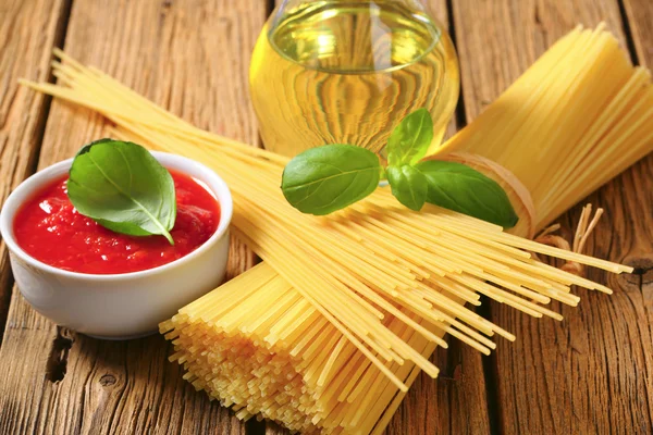 Torkade spaghetti, tomatpuré och olivolja — Stockfoto