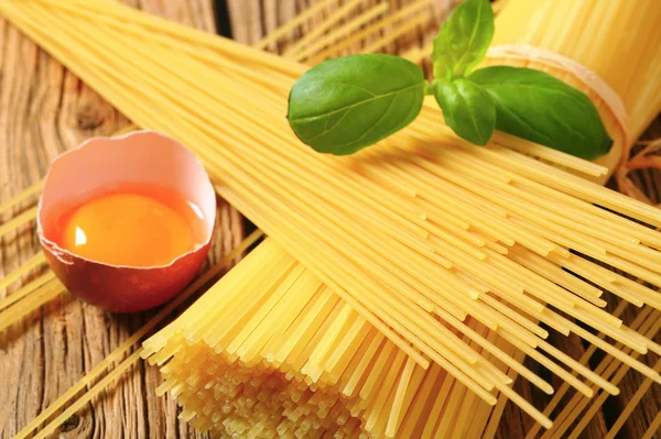 Dried spaghetti and raw egg — Stock Photo, Image