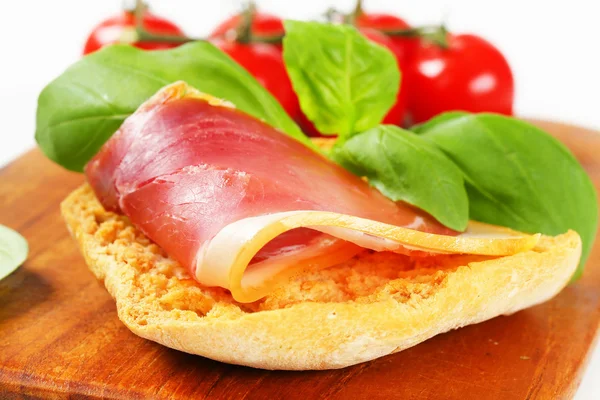 Slice of prosciutto on crispy bread — Stock Photo, Image