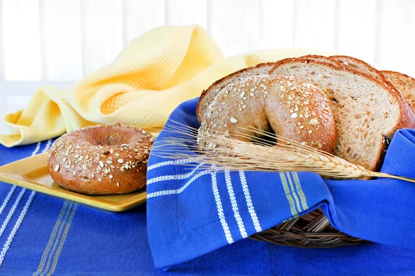 Whole wheat bagel and bread in a basket. — Stock Photo, Image