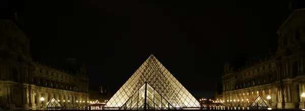 Лувр, Пирамида, завершенная в 1989 году (ночью), Франция — стоковое фото