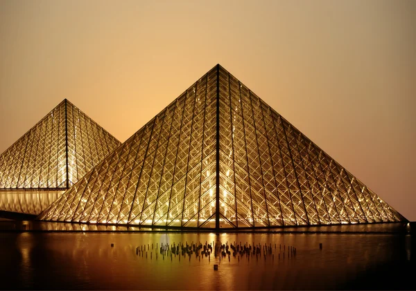 法国的卢浮宫玻璃金字塔下的 （通过夜) — 图库照片