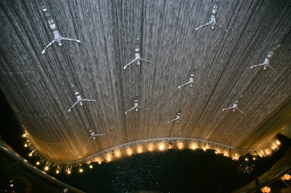 Flying men at the waterfall in the Dubai Mall. Dubai, UAE — Stock Photo, Image