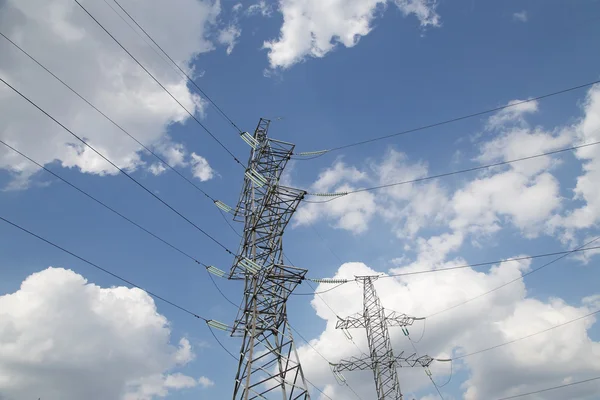 Electricity pylons and line against the blue sky and clouds — Stock Photo, Image