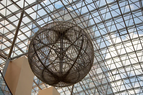 Large metal ball against the glass roof — Stock Photo, Image