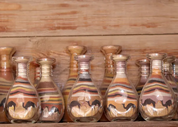 传统的当地纪念品在约旦瓶用沙子和形状的沙漠和骆驼 — 图库照片