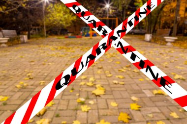 Moskova, Rusya 'da Coronavirus. Konut alanlarından birinde (bulanık manzara) bir sonbahar gecesinde boş bir oyun alanı. Karantina işareti. COVID salgını ve seyahat kavramı